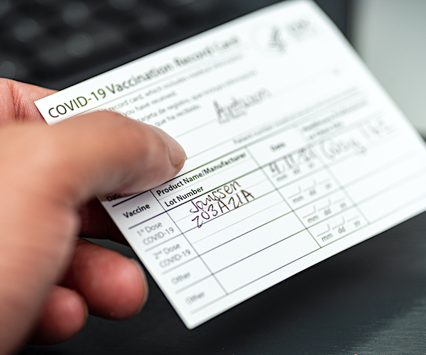 person holding a vaccination card