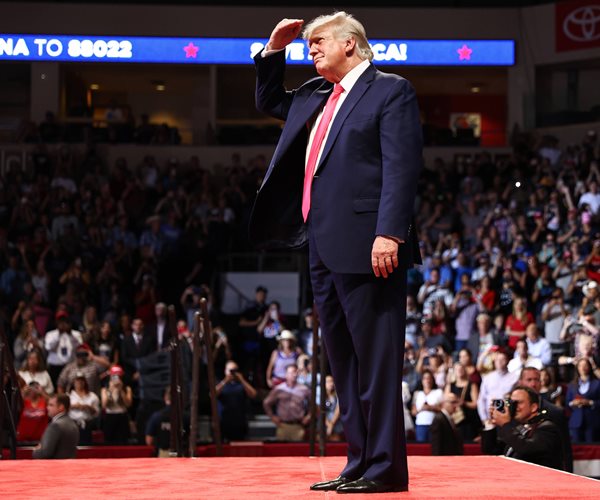 donald trump on stage with an audience around him