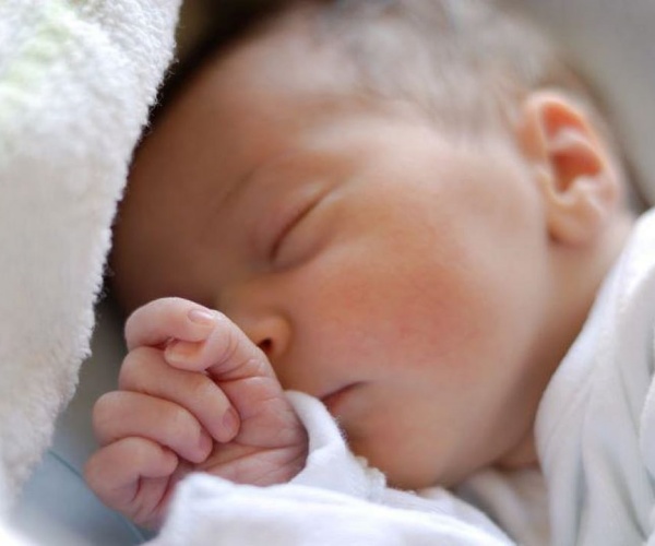 sleeping baby in white blankets