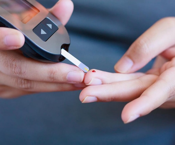 person pricking finger to get blood glucose level