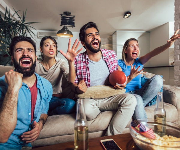 two couples cheering while watching Super Bowl