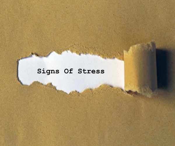 paper pulling away from the words 'signs of stress'