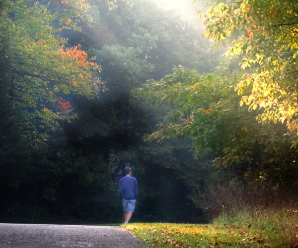 man walking in park in early morning