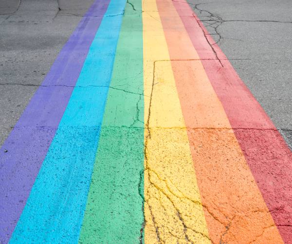 a pride flag painted on a crosswalk