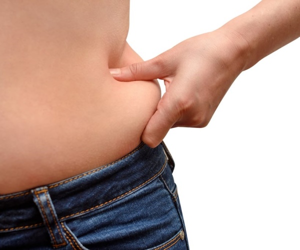 close-up of person pinching some fat on their waist