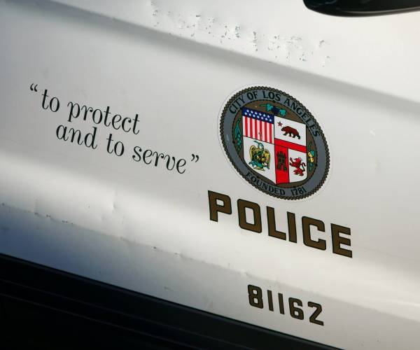 the side of a police car showing the phrase "to protect and to serve"