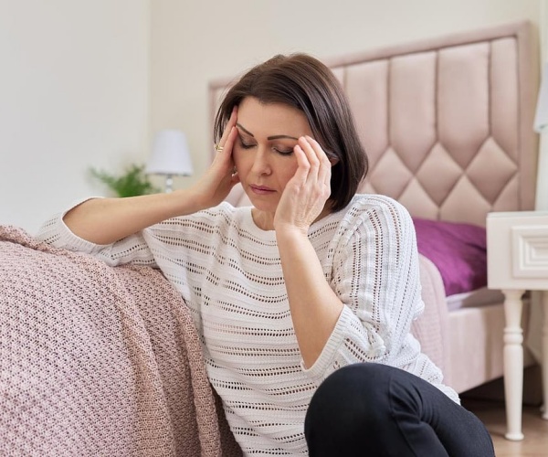 woman with migraine holding head in pain