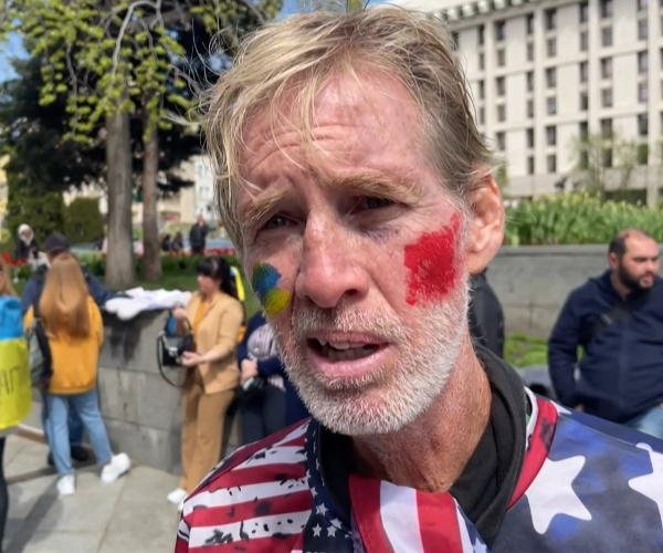 routh in an american flag shirt and wearing face paint in the colors of the ukrainian flag