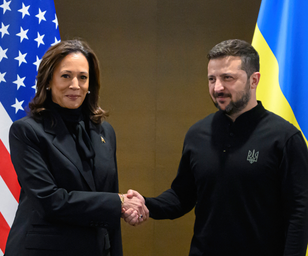 harris and zelensky shaking hands in front of american and ukrainian flags