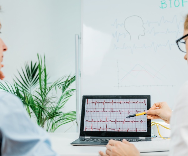 doctor showing patient biofeedback results on screen