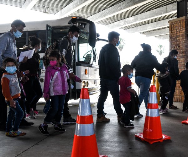 migrants exit a bus