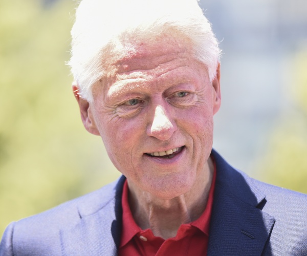 President Bill Clinton in photo wearing blue blazer, sun shining