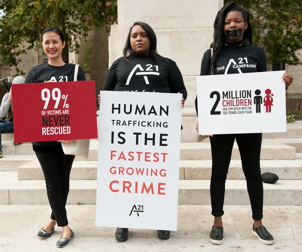 women protest human trafficking with signs