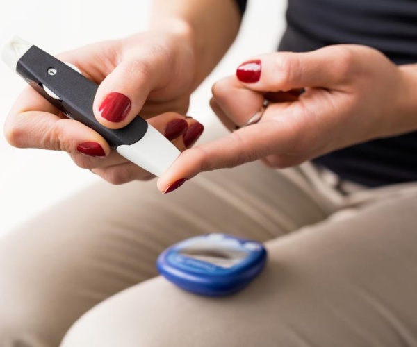 woman pricking finger for blood glucose level