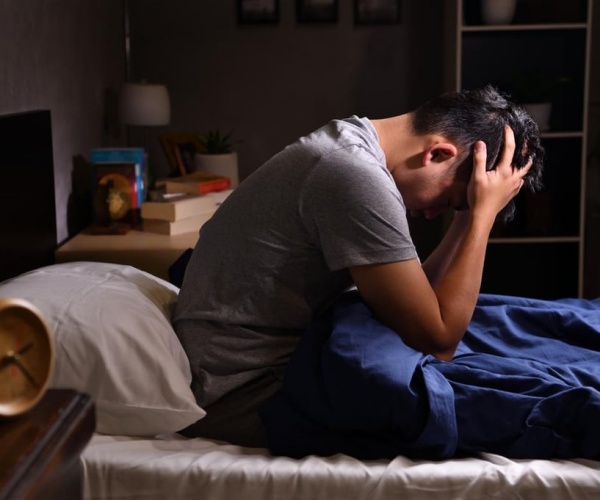 man awake in middle of night with head in hands