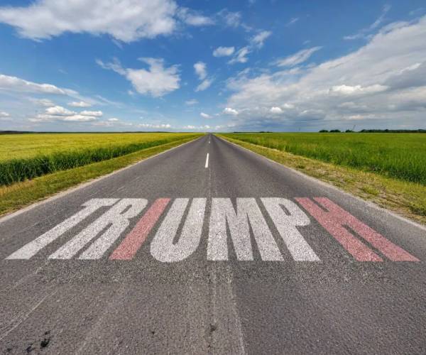 a road leading off into the horizon with triumph written on the pavement and the letters spelling trump highlighted