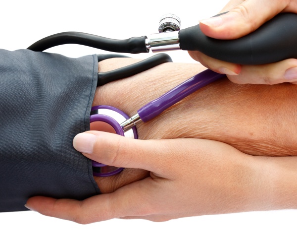 closeup of arms of doctor taking a patient's blood pressure