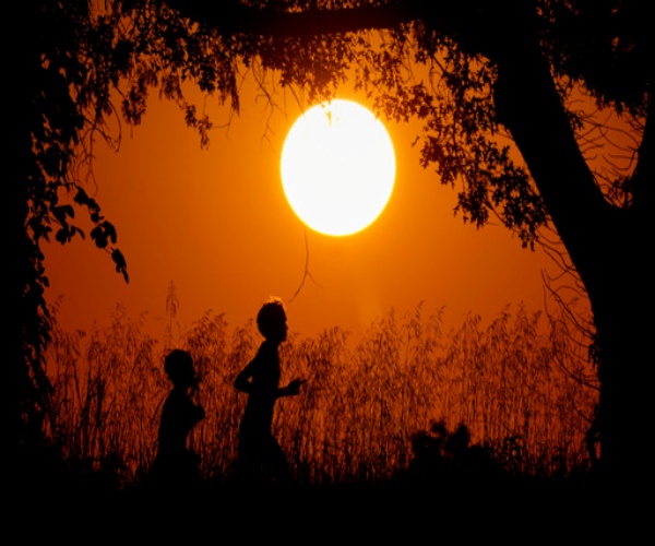 young kids running outside at sunset