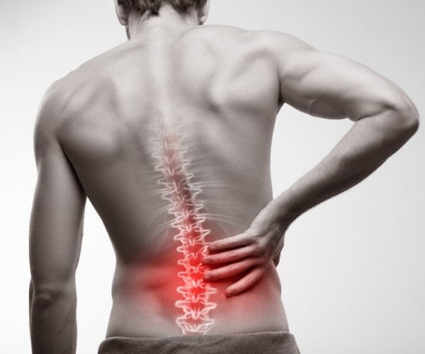 Back of a man with the spine highlighted in red indicating pain