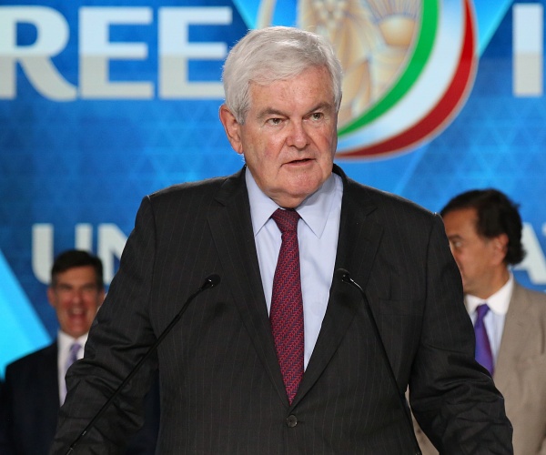 newt gingrich stands behind podium