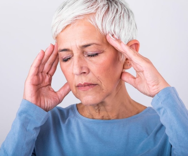 woman with hand to head with headache