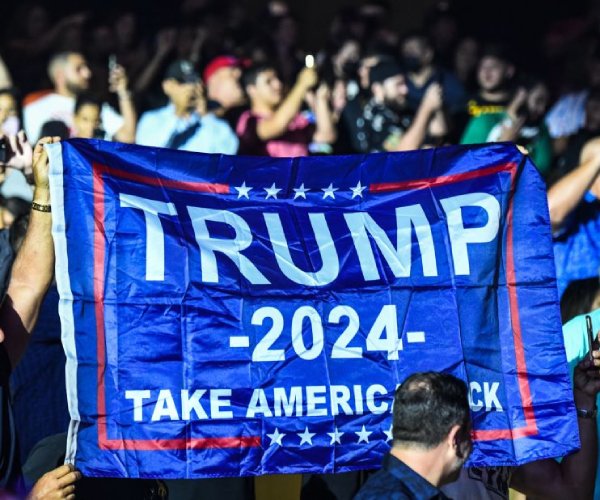 supporters of former president donald trump hold a flag