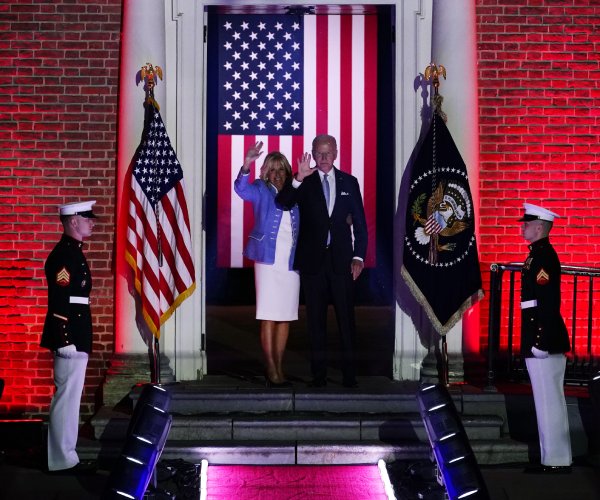 president joe biden and first lady jill biden walking between marines 