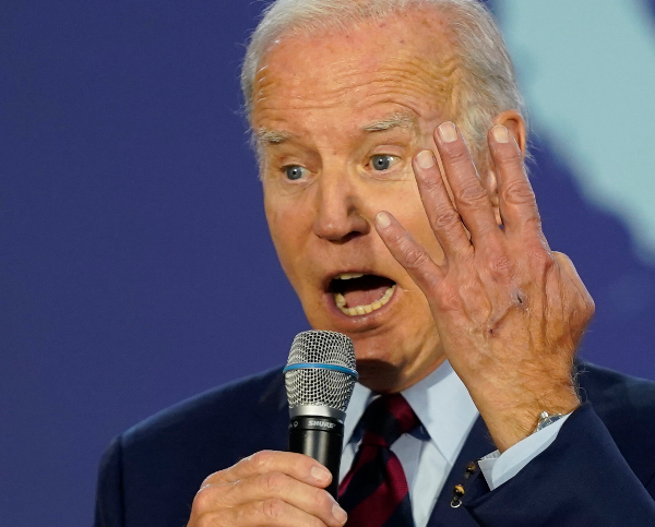 joe biden gestures while speaking into a microphone