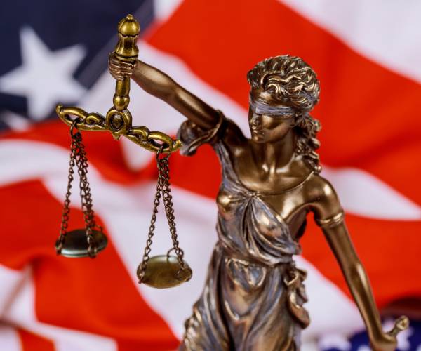 lady justice and an american flag