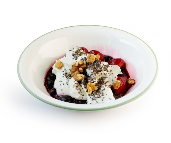 greek yogurt, walnuts, strawberries and blueberries on a white bowl