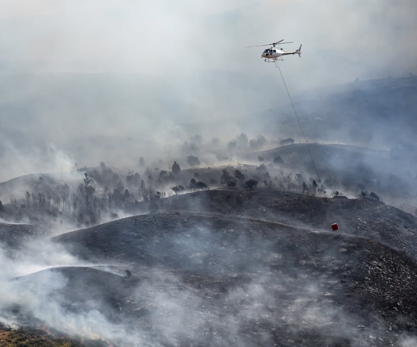 helicopter dropping water on wildfires