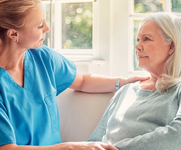 Healthcare worker talking to a woman just diagnosed with dementia