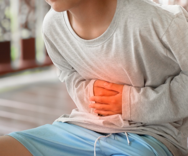 young man leaning over with stomach pain