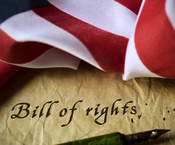 a parchment with bill of rights written on it and a pen below it