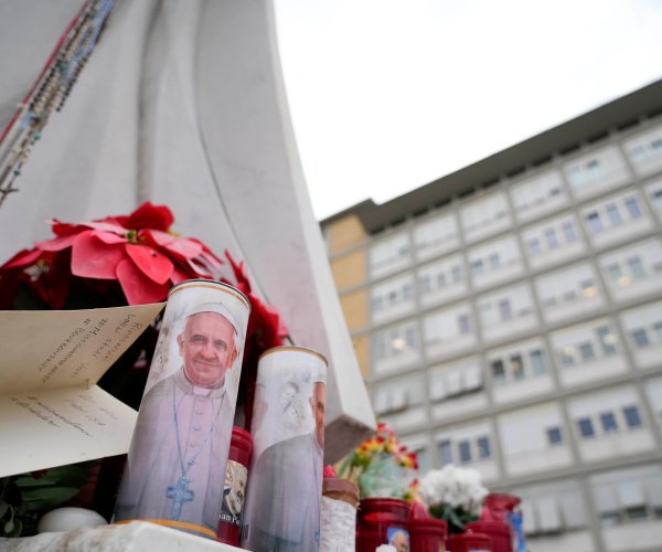 candles with Pope's face and other items placed outside hospital in Rome where the Pope is battling pneumonia