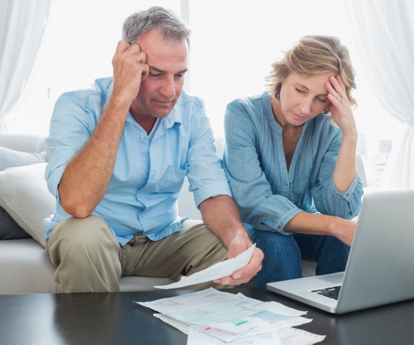 older man and woman looking stressed over bills