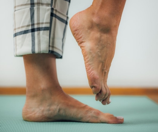 close-up of person's legs as they stand on one foot