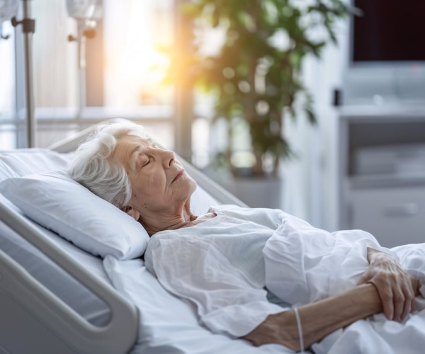 older woman in a hospital bed in nursing home