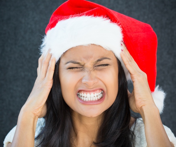 woman in Santa hat looking stressed out