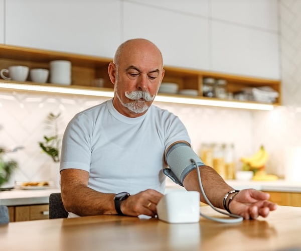 man checking his blood pressure at home