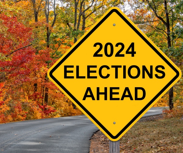 2024 election ahead caution sign with fall leaves in background