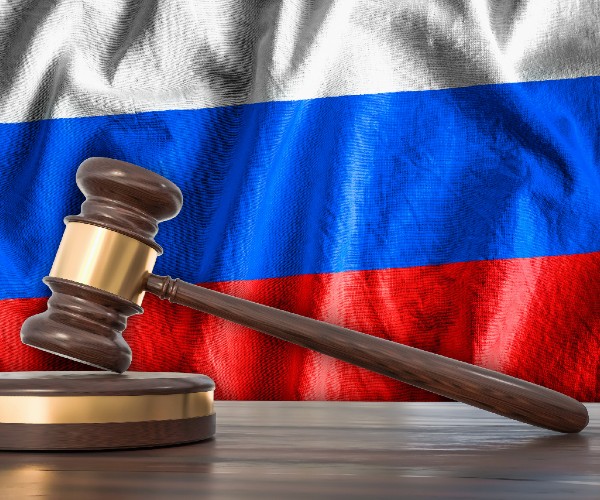 a judges gavel with the russian flag in the background