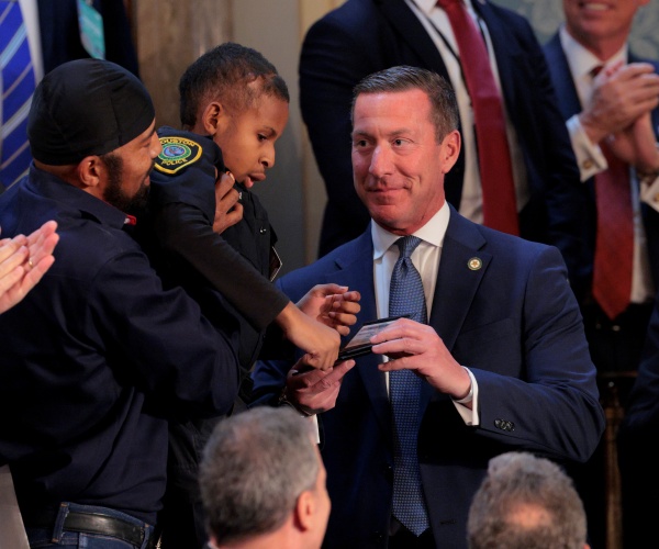 sean curran looks at dj daniel who is held by his dad.