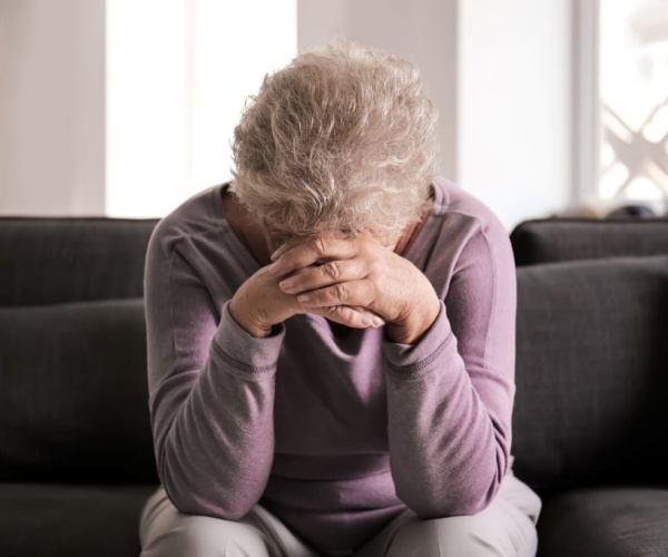 older woman with head in hands due to depression