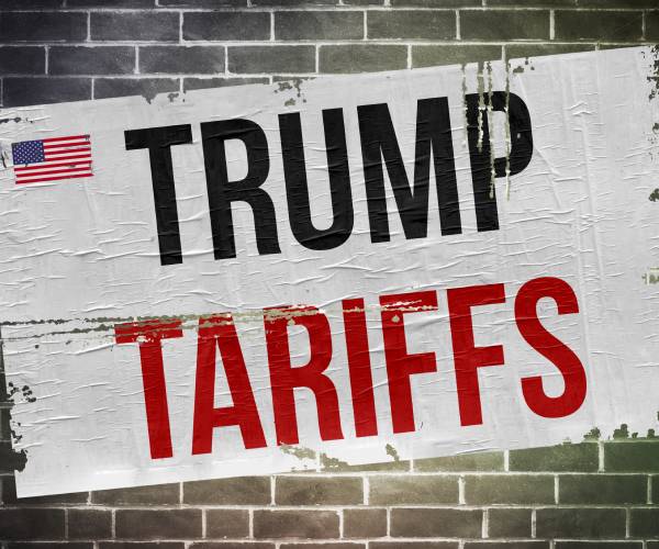 the words trump tariffs pasted on a brick wall