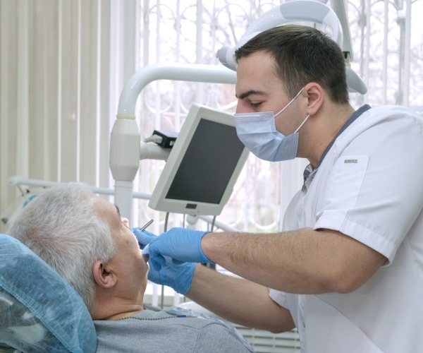 dentist working in older man's mouth