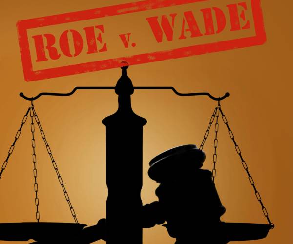 scales of justice and a gavel with the words roe v wade stamped on top