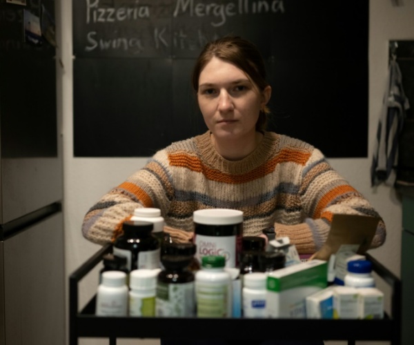 Long COVID sufferer with medicines and supplements in front of her