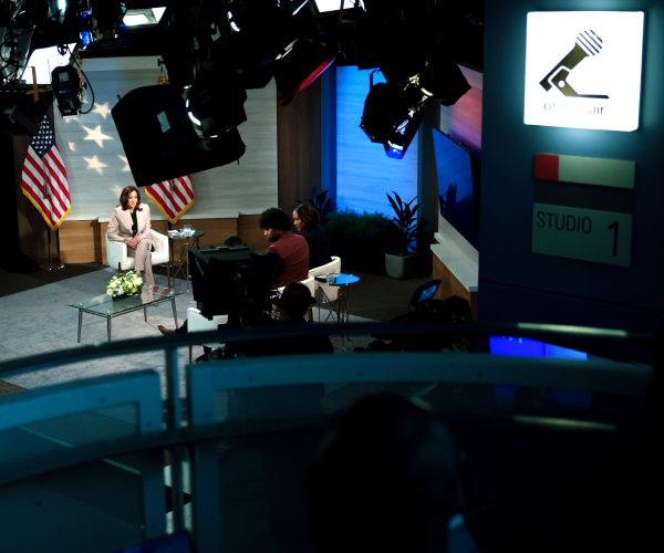 kamala harris on stage in a tv studio with journalists