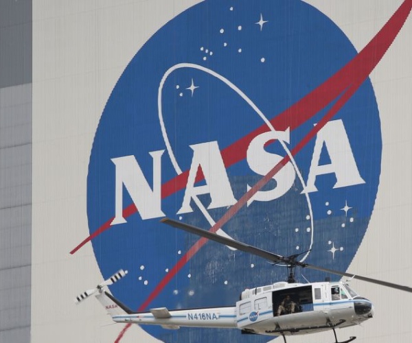 nasa security helicopter flies past the vehicle assembly building 